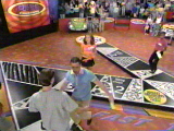The contestants stand on the game board